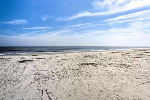 Ein Strand mit klarem Himmel und ruhigem Wasser.