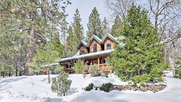 A log cabin with a wrap-around porch, surrounded by snow and trees. - Near Bear Valley: Peaceful Arnold Home w/ Hot Tub (Arnold)