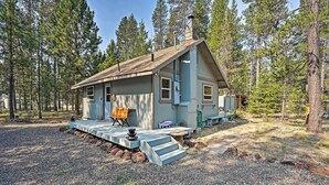A rustic cabin with a wooden deck, a chimney, and a small porch area. - High Lakes Hideaway: La Pine Fishing Cabin! (La Pine)