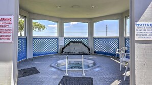 A hot tub area with a view of the ocean, a lifeguard warning sign, and a notice about shower requirements. - Charming Port Clinton Condo w/ Community Amenities (Port Clinton)