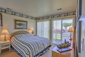 A hotel room with a large bed, two bedside lamps, a ship model on a table, and a painting on the wall. - Charming Port Clinton Condo w/ Community Amenities (Port Clinton)