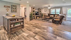Un salón amplio con suelo de madera, una chimenea, un sofá y una mesa de centro.