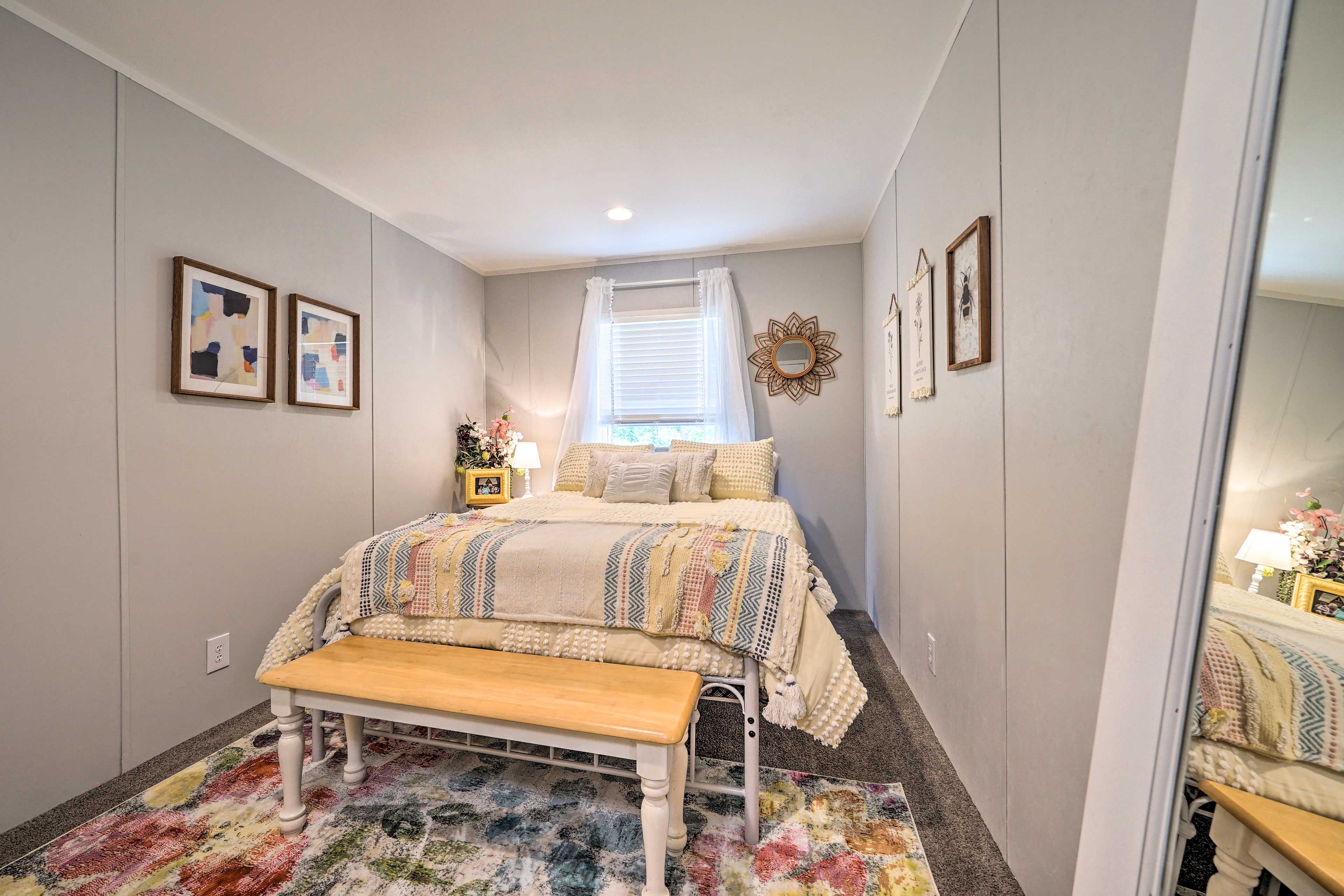 Ein Schlafzimmer mit Bett, Sitzbank und einem Vorhangfenster.