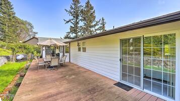 A patio with a table and chairs, a covered seating area, and a sliding glass door leading to a covered outdoor space.
