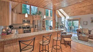 Una cocina amplia con armarios de madera, encimera de granito y una isla grande con taburetes de bar.