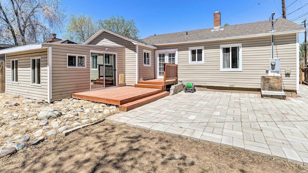 Ein zweistöckiges Haus mit einer Veranda, einer Garage und einem gepflasterten Einfahrt.