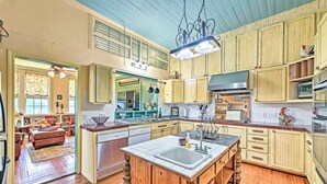 A spacious kitchen with wooden cabinets, a central island, and a dining area with a sofa and table.