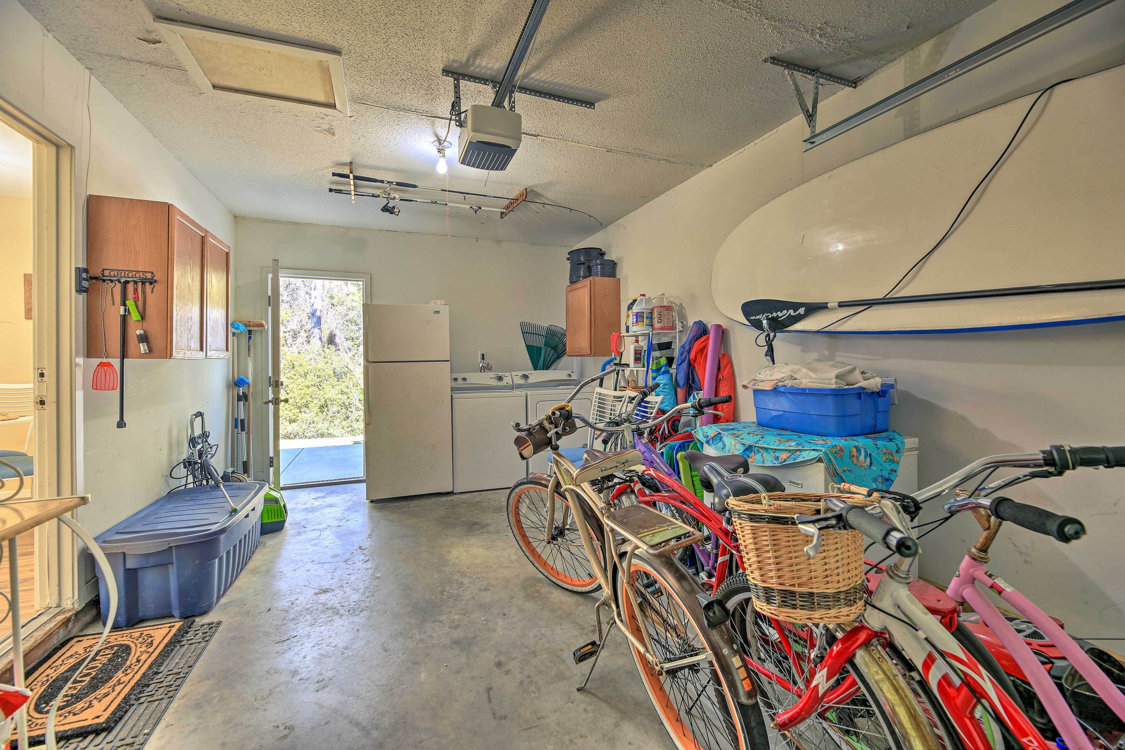 A garage with bicycles, a washing machine, and a kitchen area.