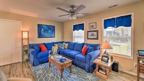 A living room with a blue sofa, a coffee table, and a ceiling fan. - Beaufort Pad w/ Patio: 3 Blocks to Waterfront! (Beaufort)