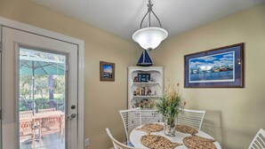 A dining area with a white table, chairs, and a ceiling light fixture. - Beaufort Pad w/ Patio: 3 Blocks to Waterfront! (Beaufort)