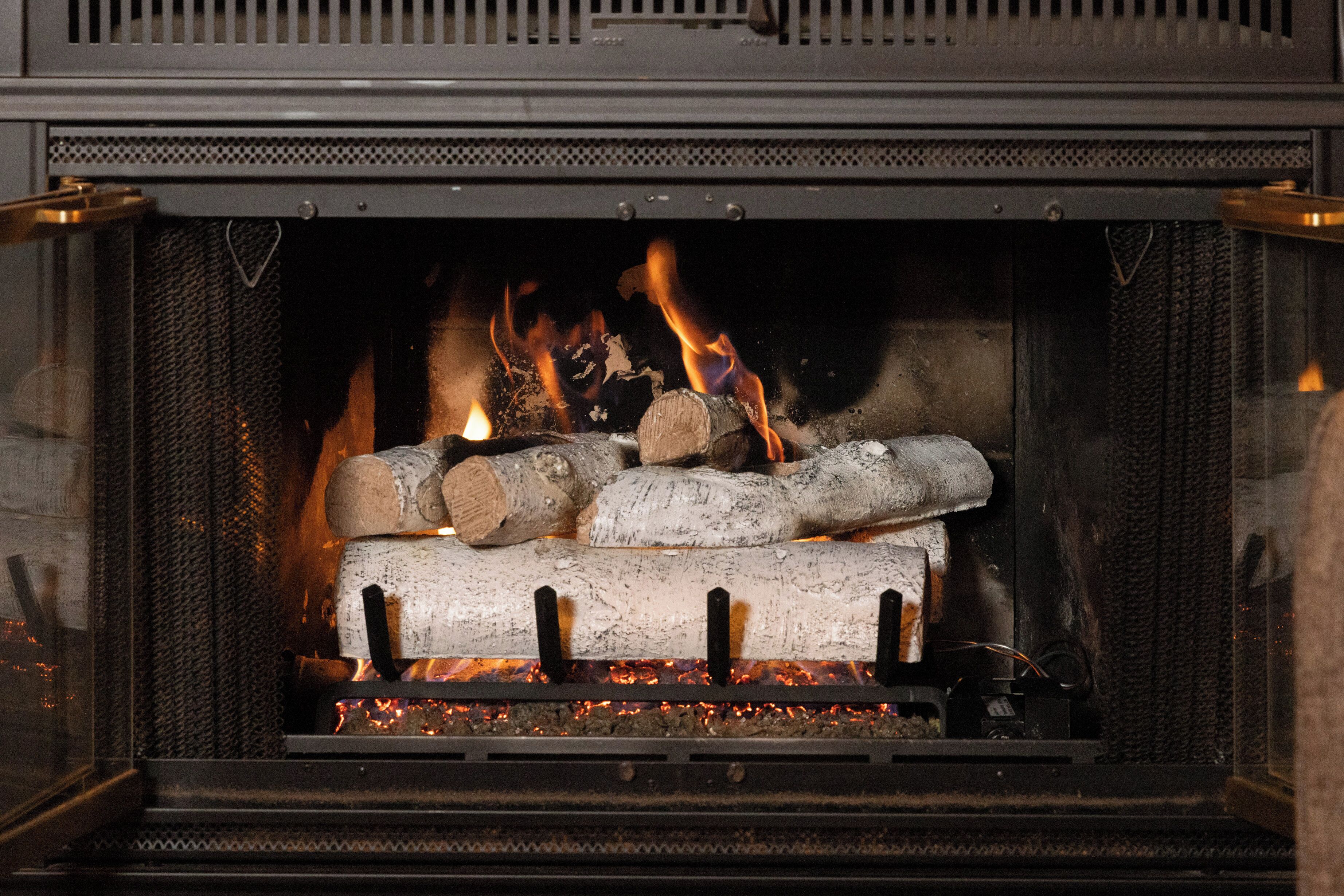 A fireplace with logs and burning embers.