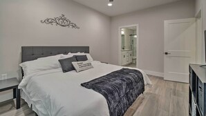 A bedroom with a bed, a ceiling fan, a bedside table, and a wardrobe. - Well-appointed Montgomery Home w/ Fenced Yard (Montgomery)