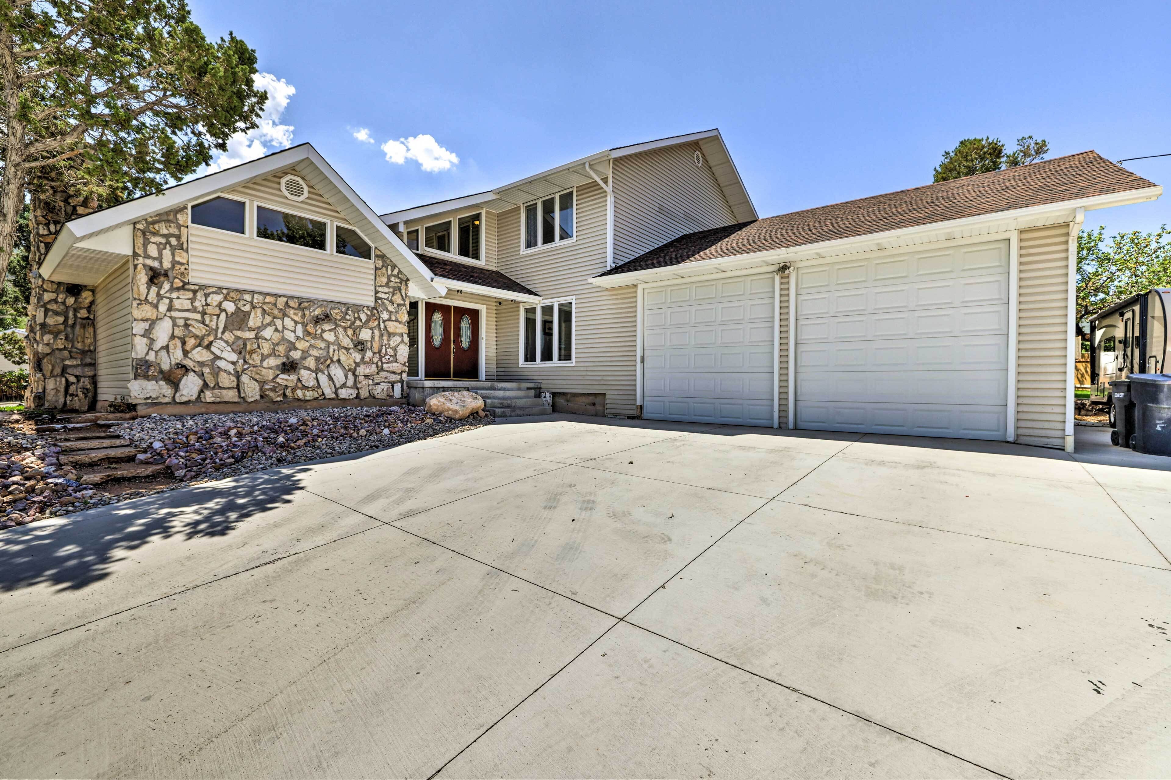 A two-story house with a stone facade, a garage, and a driveway.