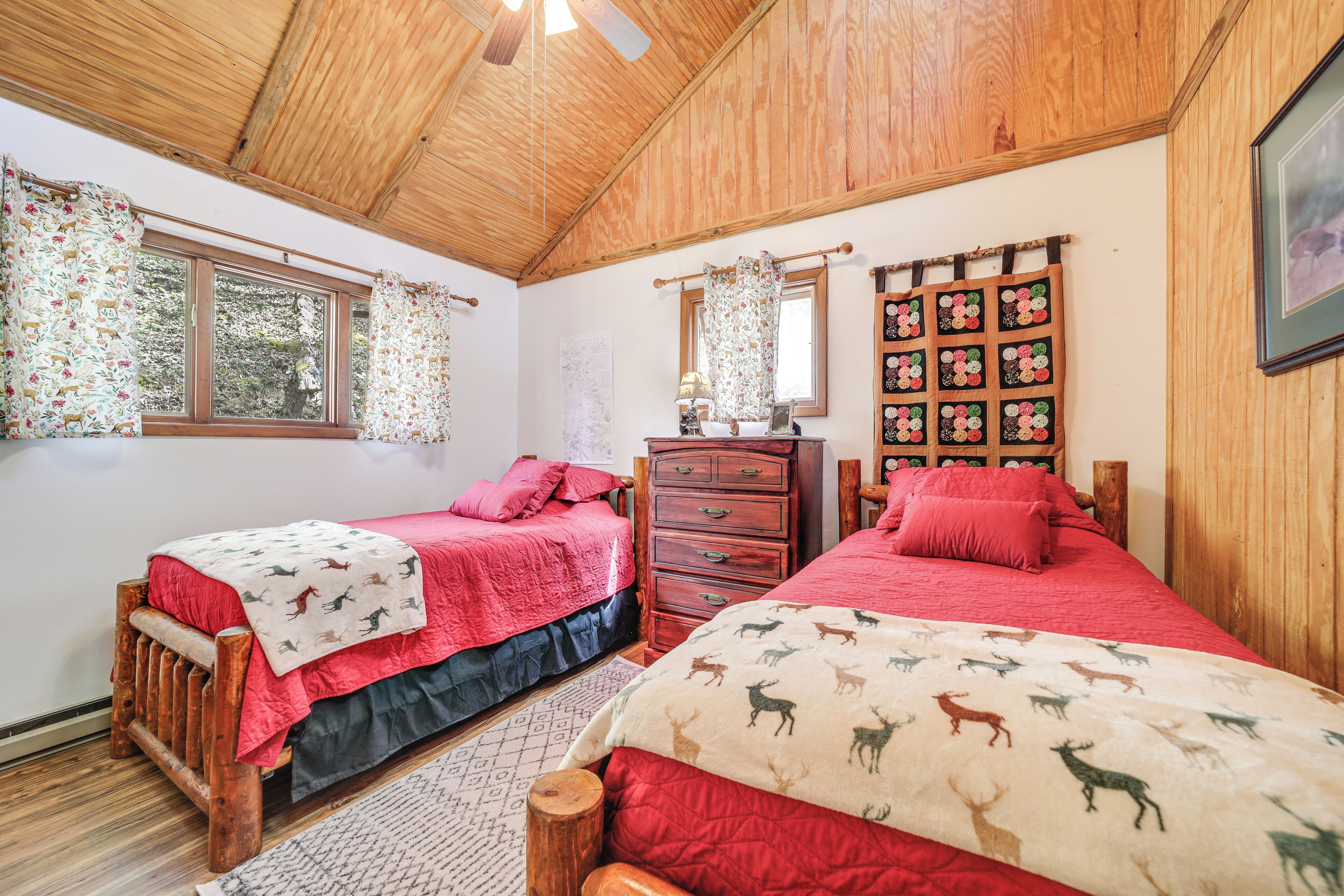 Een slaapkamer met twee bedden, houten meubels en een kledingkast.