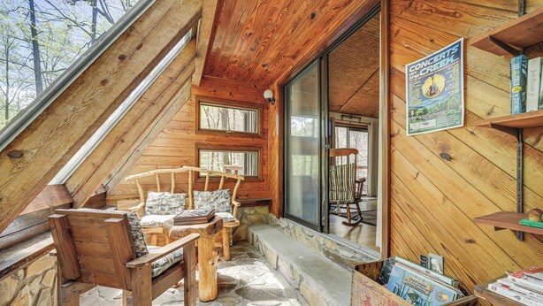 Un accogliente chalet con pavimento in pietra, mobili in legno e un poster che pubblicizza concerti.