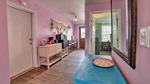 A hallway with a blue table, a white door, and a mirror on the wall. - Bayfront Deck: 'casa Pescadores' Rockport Escape (Rockport)
