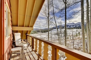A wooden deck with chairs and a view of snow-covered mountains and trees. - Cozy Mtn Home ~ 2 Mi to Breck Resort & Main St! (Breckenridge)