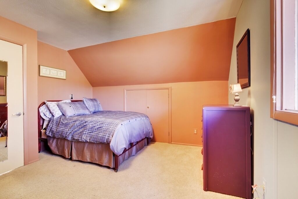 Un dormitorio con cama, cómoda y puerta.