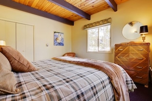 A bedroom with a plaid bedspread, a wooden dresser, a mirror, and a painting on the wall. - Cozy Mtn Home ~ 2 Mi to Breck Resort & Main St! (Breckenridge)