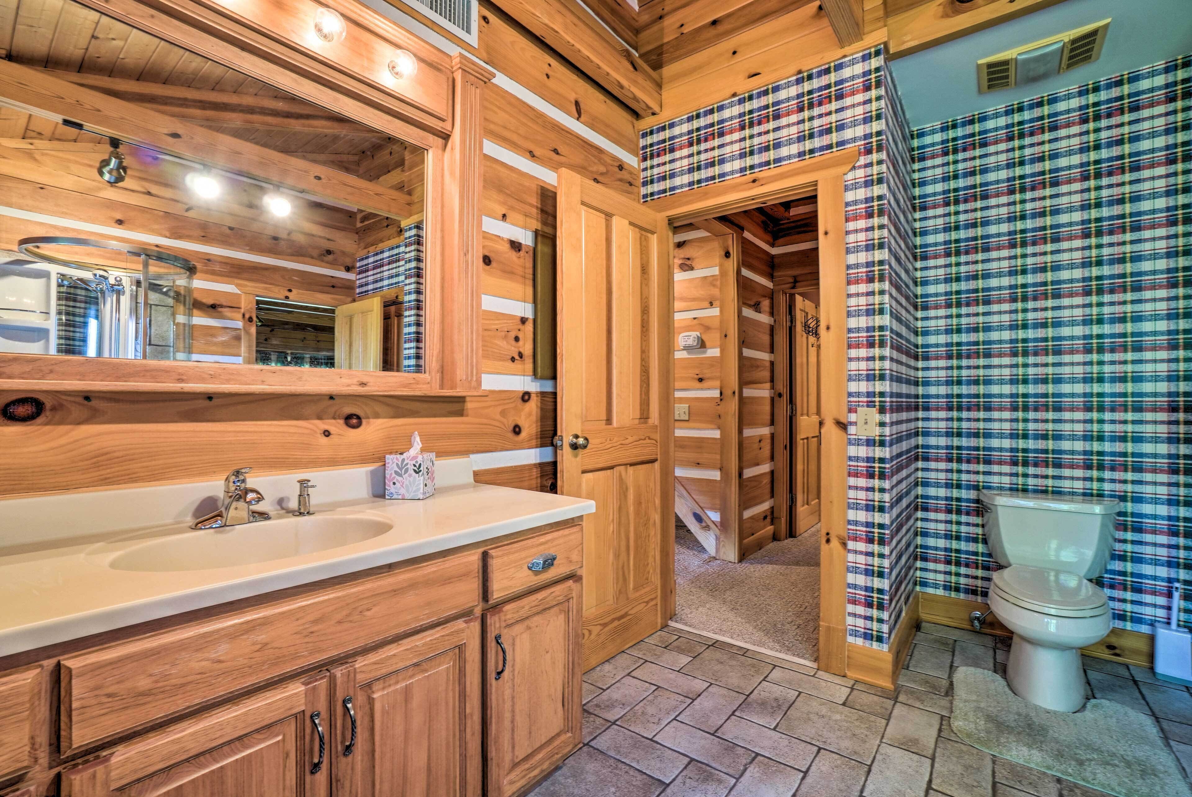 Ein Badezimmer aus Holz mit einem großen Spiegel, einem Waschbecken und einer Toilette.
