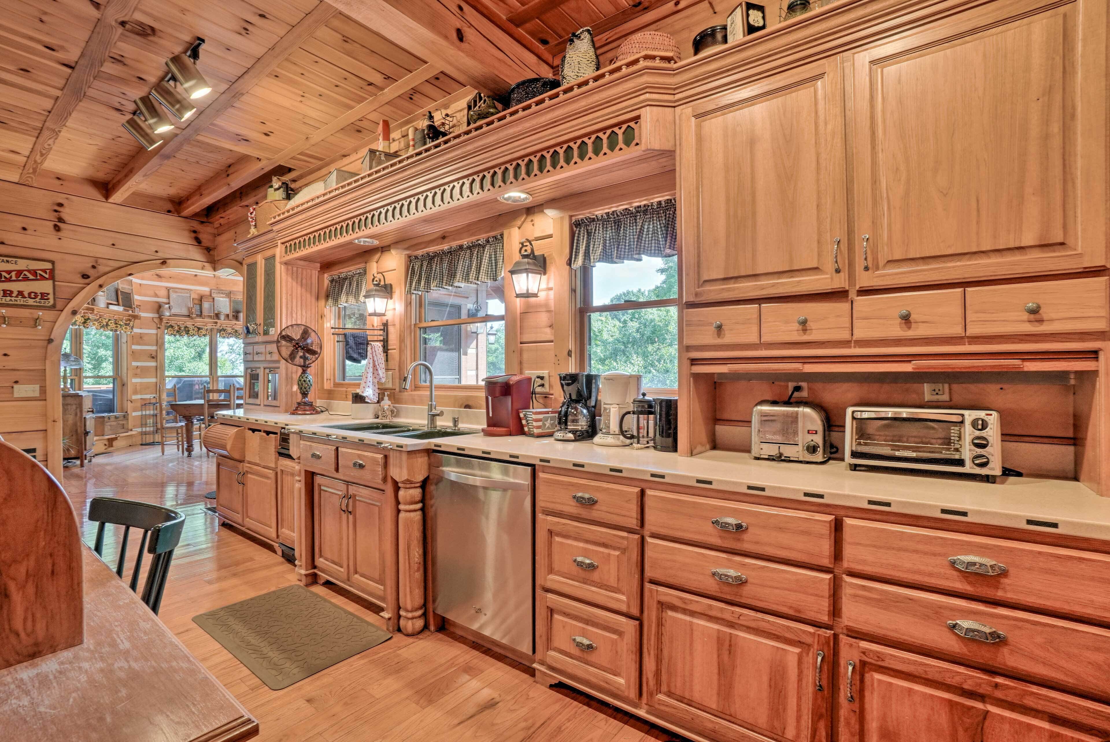 A wooden cabin-style kitchen with a central island, built-in appliances, and a large window.