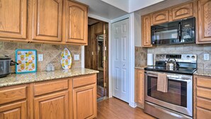 A kitchen with wooden cabinets, a stainless steel oven, and a microwave.