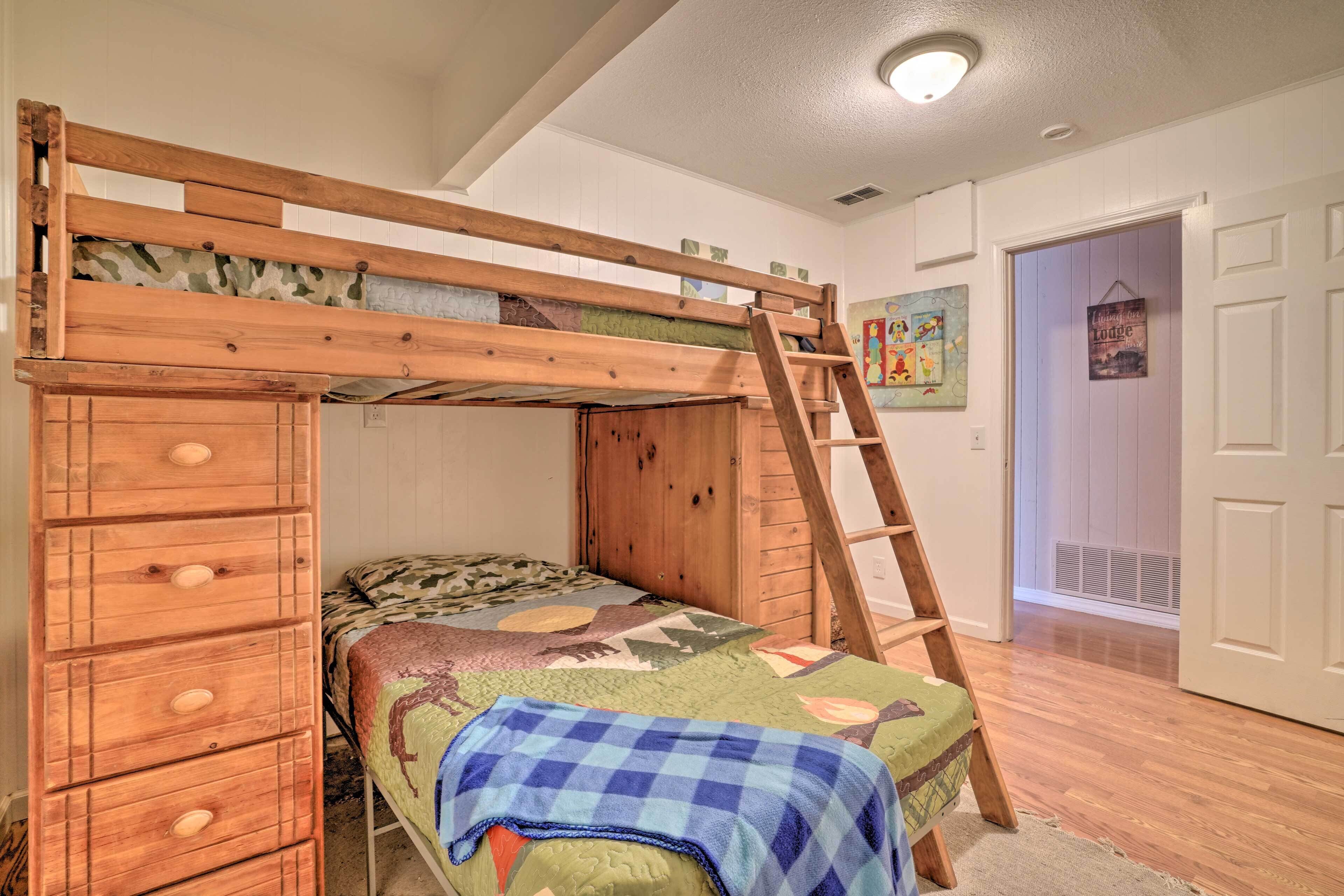 A bunk bed with a ladder, a dresser, and a quilted bedspread.