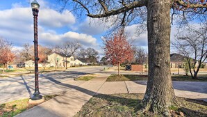A street with a tall lamp post, a large tree, and houses in the background. - Home: Grassy Yard, Walk to Bentonville Square (Bentonville)