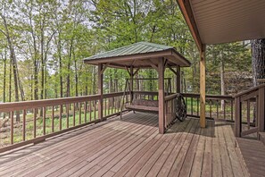 Eine Holzterrasse mit Schaukelstuhl und überdachter Laube.