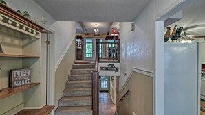 A staircase with a wooden handrail, carpeted steps, and a 'Gone Fighting' sign.