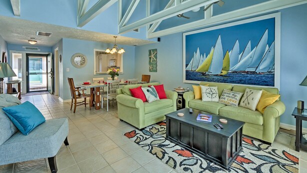 A spacious living room with a high ceiling, a dining area, and a kitchen.