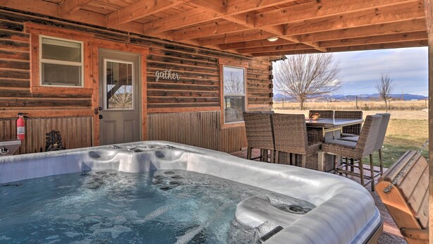 A wooden cabin with a hot tub, outdoor seating, and a view of the landscape. - Secluded Cabin w/ Hot Tub, Game Room & Views! (Durango)