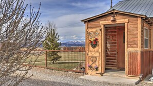 A wooden cabin with a sign reading "WELCOME TO THE FENCE" and a bell. - Secluded Cabin w/ Hot Tub, Game Room & Views! (Durango)