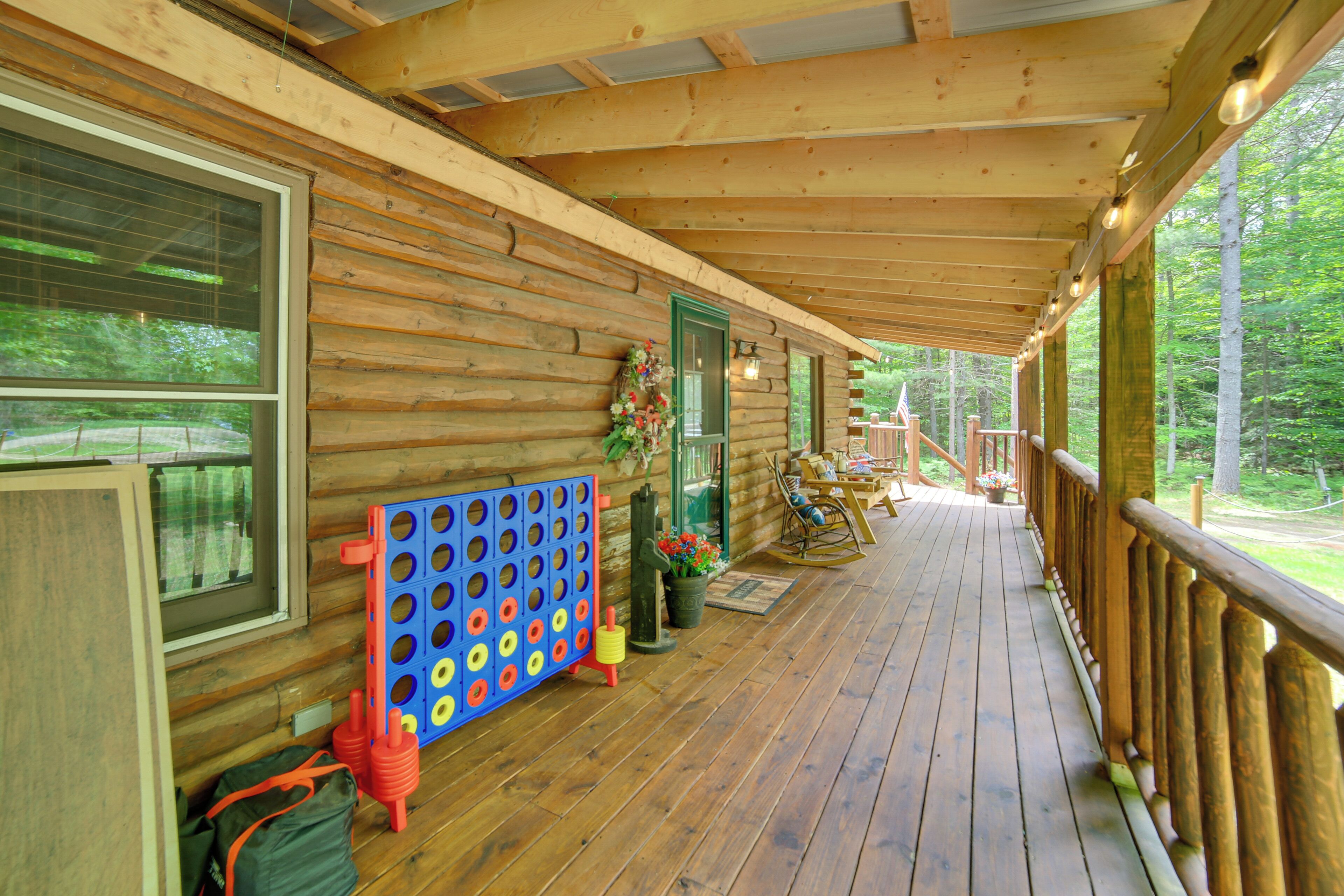 A wooden cabin with a porch, a blue board game, and a rocking chair.
