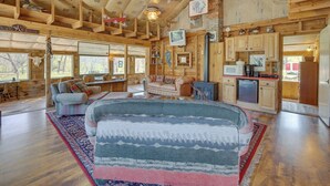 A spacious living room with a large sofa, a fireplace, and wooden beams on the ceiling. - The Ranch at Keystone: 9 Mi to Mount Rushmore! (Keystone)