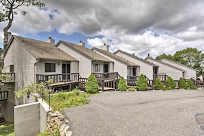 A row of single-story cabins with wooden decks and small coniferous trees in front. - Year-round Fun in Beech Mountain! Condo w/ Balcony (Banner Elk)