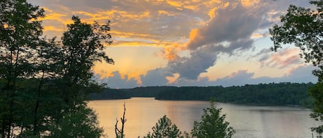 Un lago rodeado de árboles bajo un cielo de atardecer.