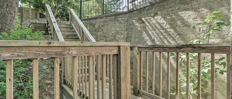 A wooden staircase with a metal railing leading up to a concrete wall.