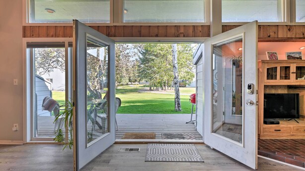 Un intérieur de maison moderne avec une grande porte vitrée donnant sur un jardin.