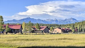 Une rangée de cabanes aux toits rouges, se dressant sur un fond de montagnes et d’un ciel dégagé.
