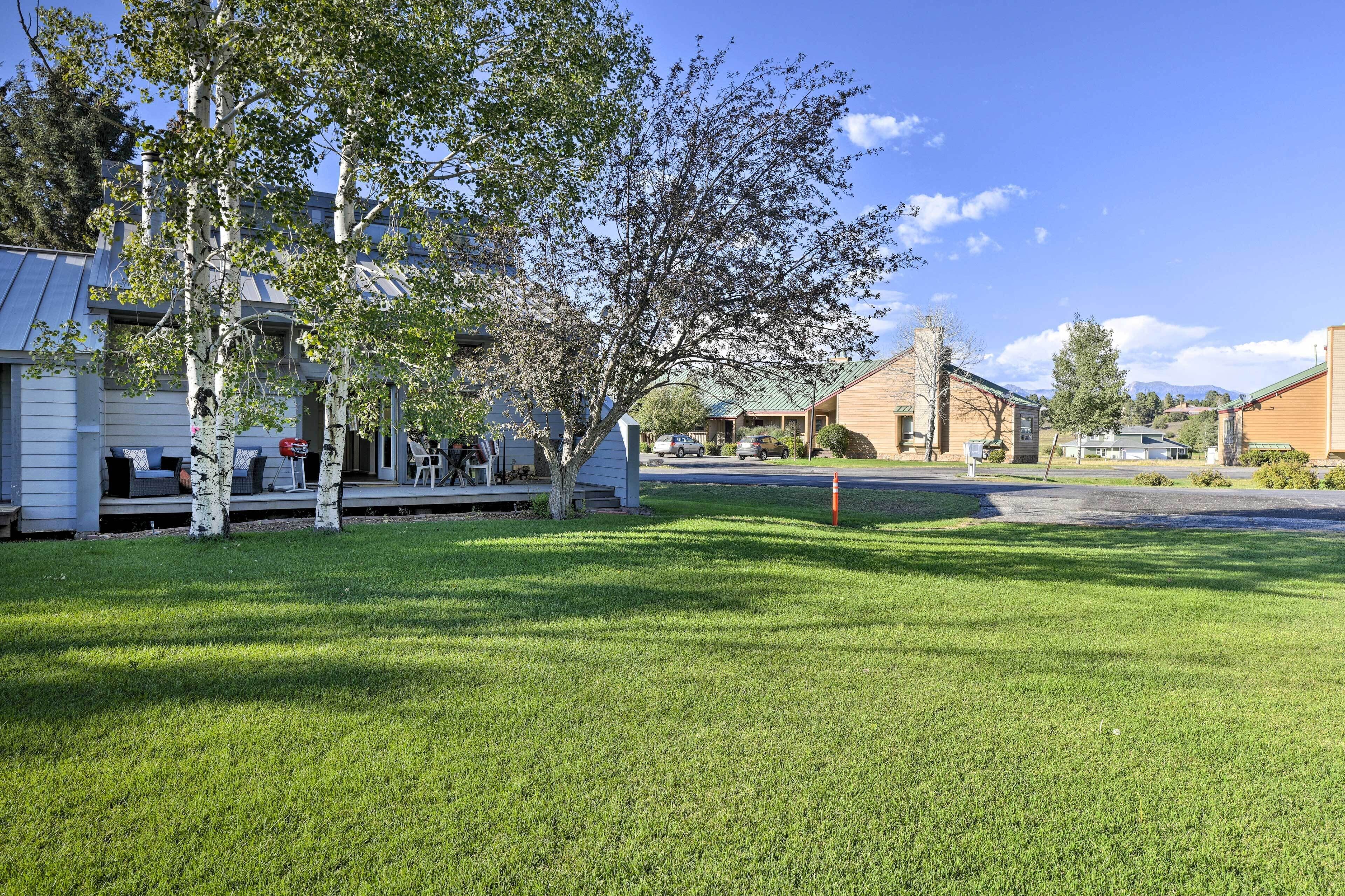 A residential area with houses, a grassy lawn, and a clear sky.