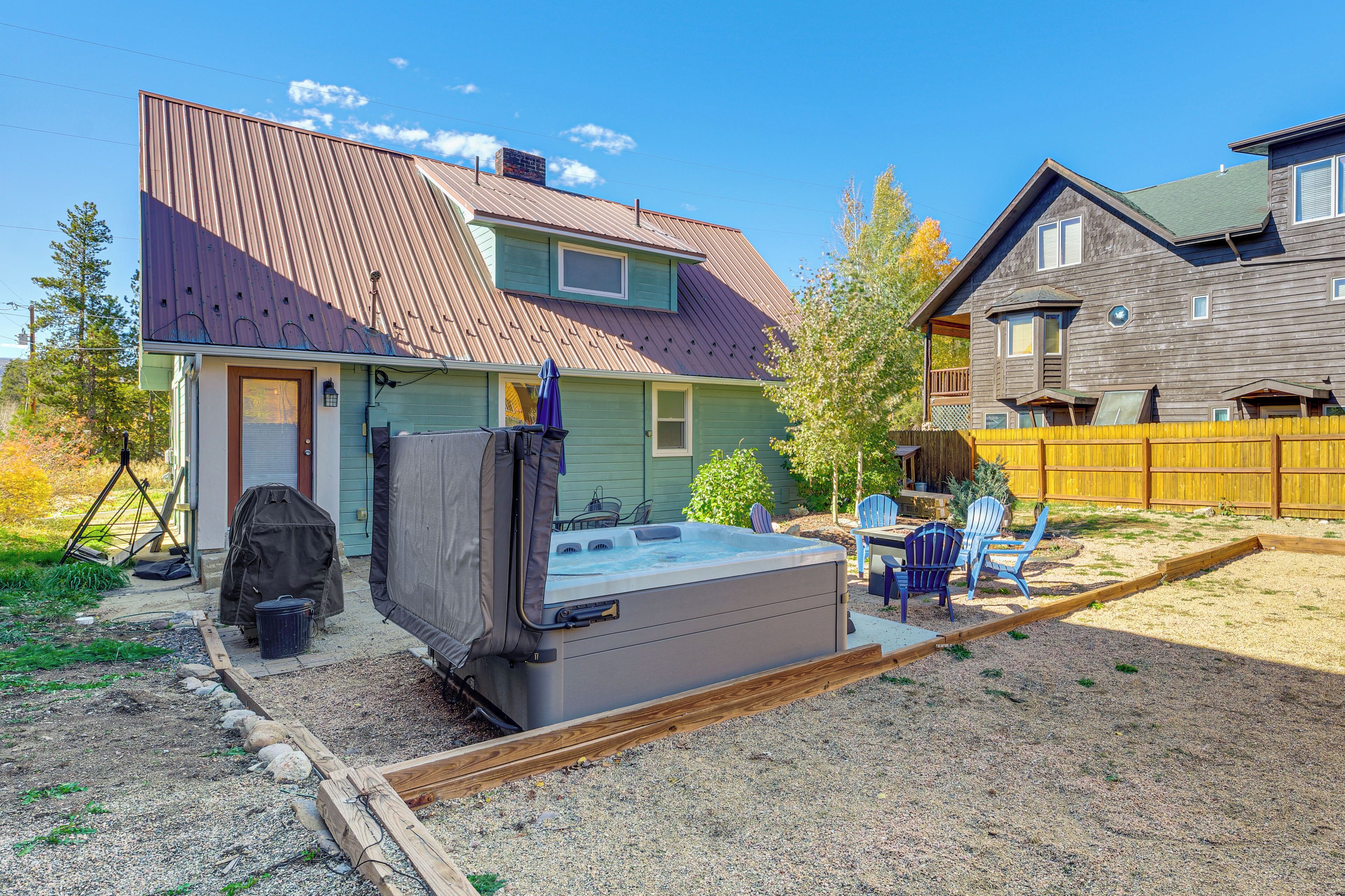 A house with a hot tub, outdoor seating, and a fenced yard.