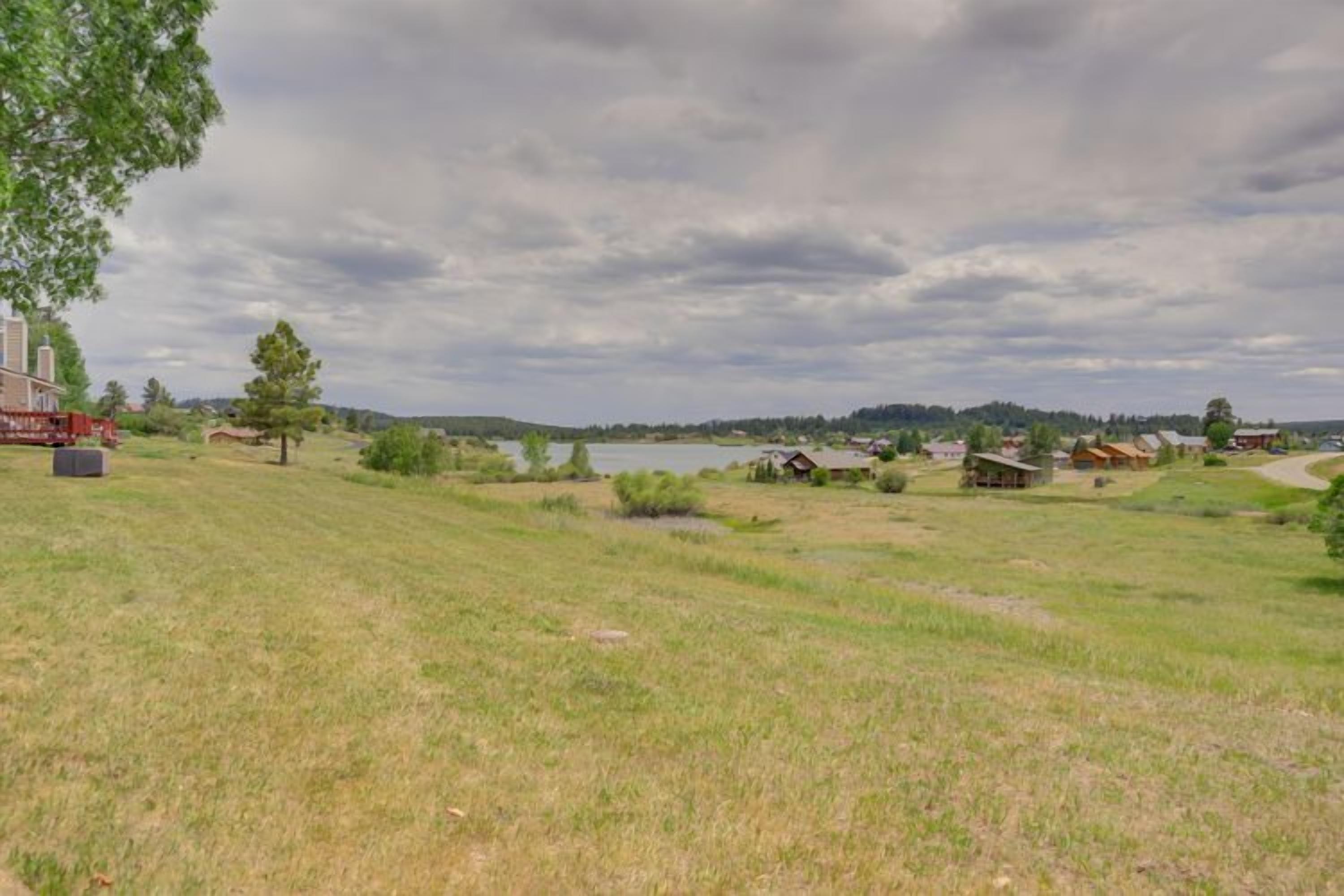 A rural landscape with a lake, scattered houses, and a red truck.