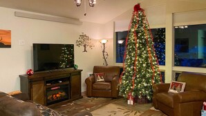 A living room with a fireplace, a television, a Christmas tree, and two armchairs. - 3 Mi to Rmnp! Mtn-view Retreat in Estes Park (Estes Park)