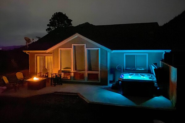Una casa con patio, fogata y jacuzzi.