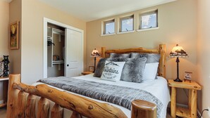 A bedroom with a wooden headboard, a bed with a gray and white striped blanket, two bedside lamps, and a window with a view of the sky. - 3 Mi to Rmnp! Mtn-view Retreat in Estes Park (Estes Park)