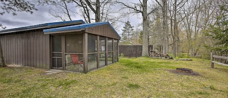 Un petit bâtiment d’un seul étage, doté d’une porte et de fenêtres en verre, entouré d’une cour verdoyante et d’arbres.
