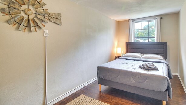 Ein Schlafzimmer mit einem Bett, einer Wanduhr und einem Fenster.
