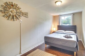 A bedroom with a bed, a wall clock, and a window. - Half-mi to Marina: Pet-friendly Disney Home (Disney)