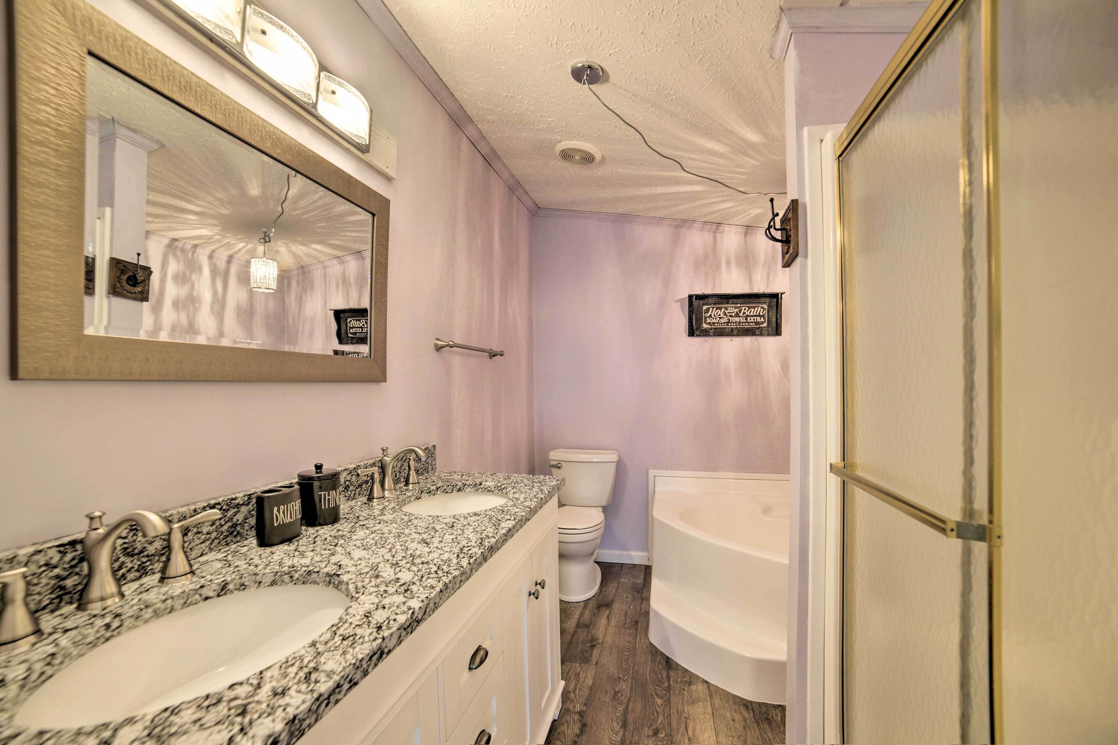 Un baño con dos lavamanos, inodoro y bañera.